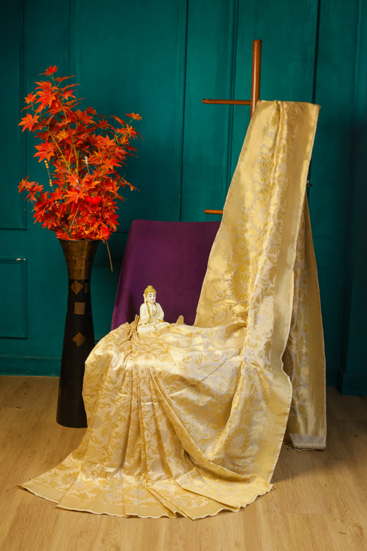 Yellow fabric draped over a chair with a teal wall and red flowers in the background