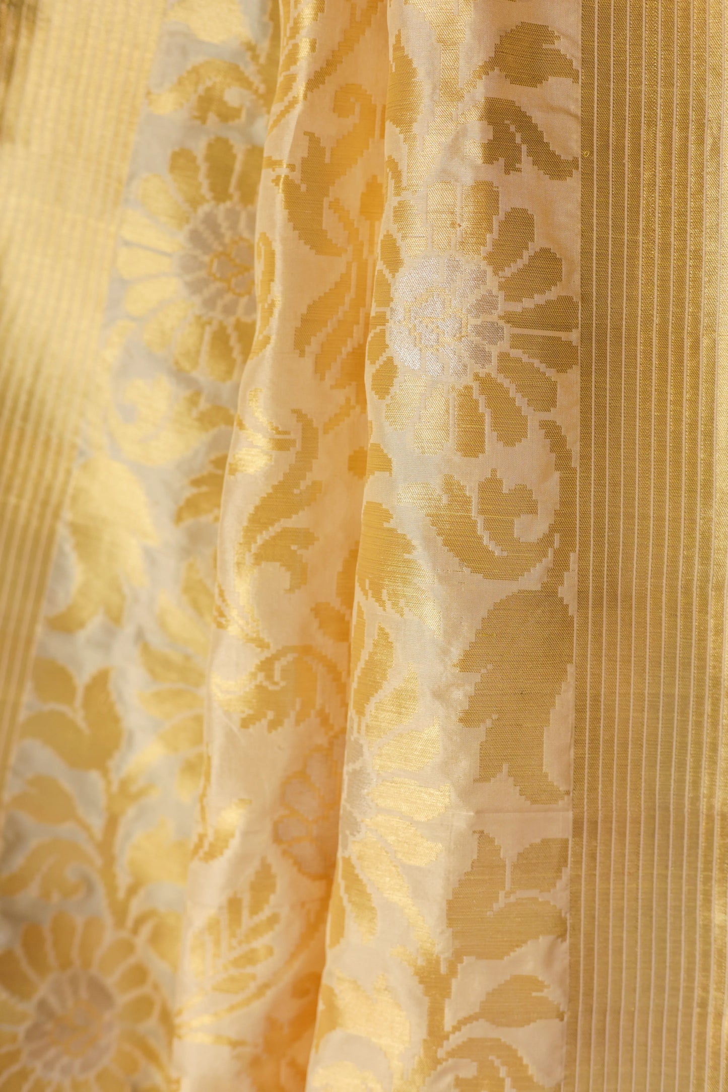 Yellow fabric draped over a chair with a teal wall and red flowers in the background