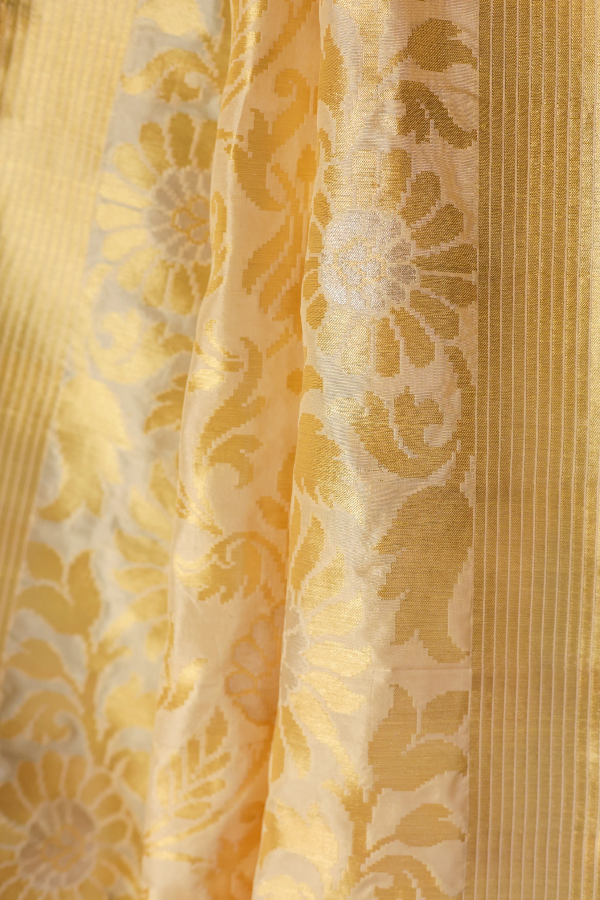 Yellow fabric draped over a chair with a teal wall and red flowers in the background